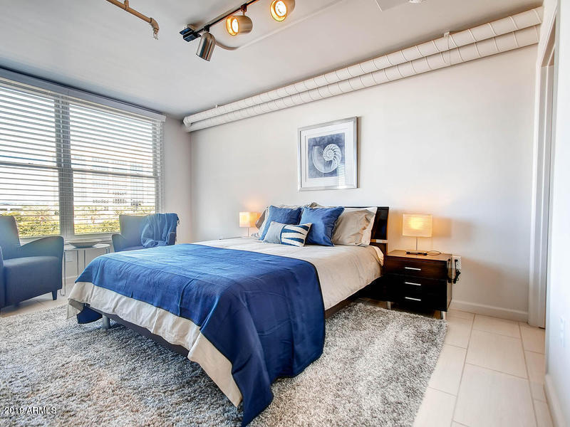 535 West Thomas Road, Unit 211 Phoenix, AZ 85013 - Photo 6 of 24 a bedroom with a bed and a couch