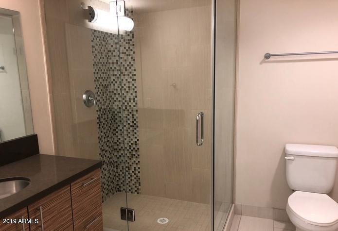 535 West Thomas Road, Unit 211 Phoenix, AZ 85013 - Photo 9 of 24 a bathroom with a granite countertop sink toilet and shower