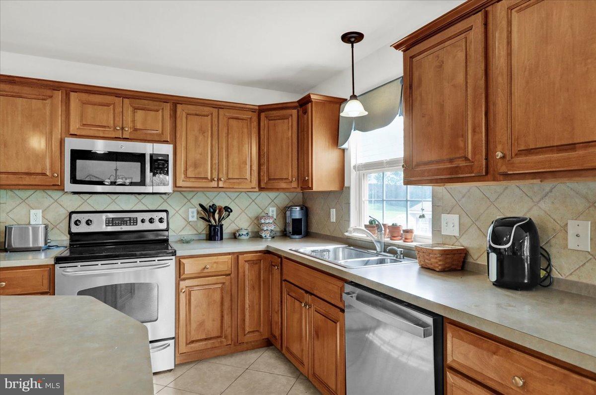 2509 Joshua Drive Sinking Spring, PA 19608 - Photo 6 of 35 a kitchen with stainless steel appliances granite countertop a sink a stove and a microwave