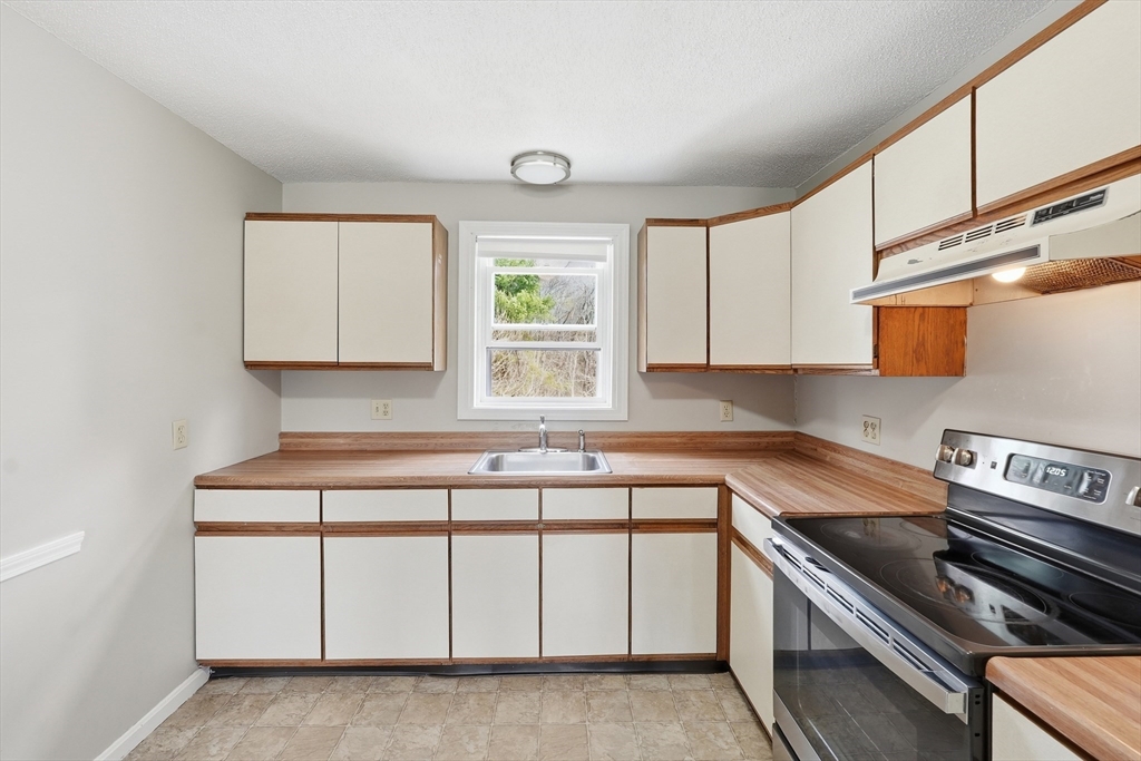 146 Hecla Street, Unit 2 Uxbridge, MA 01569 - Photo 11 of 26 a kitchen with stainless steel appliances granite countertop a stove a sink and a microwave