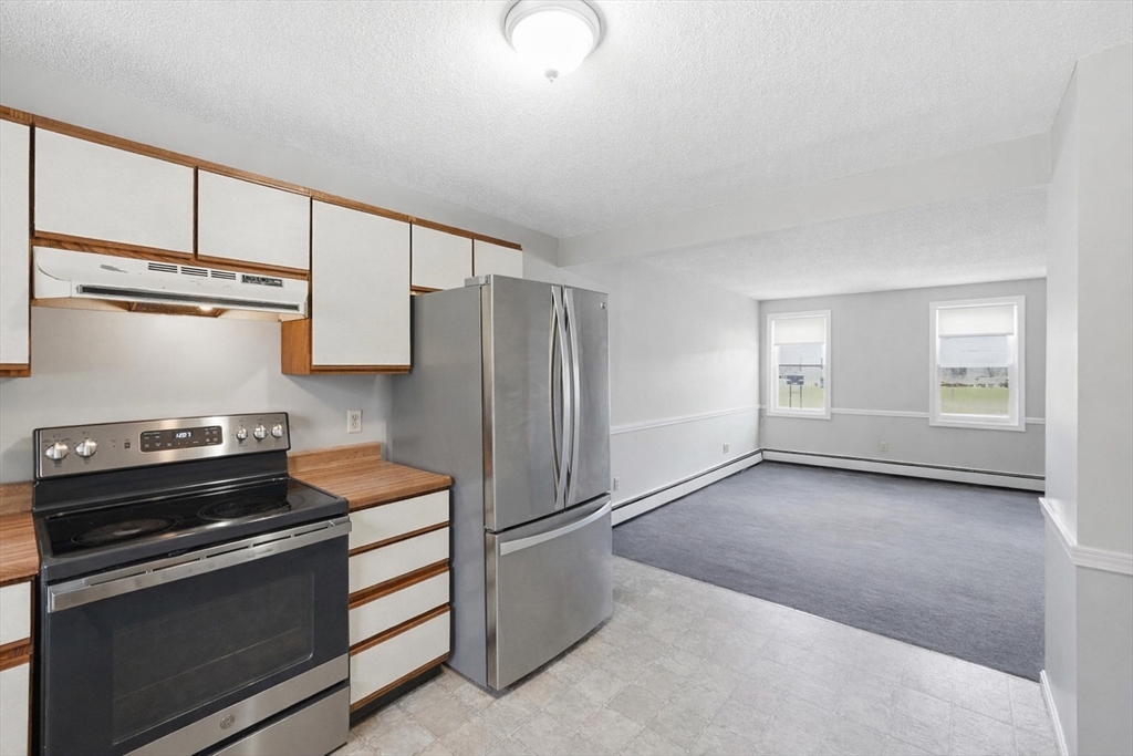 146 Hecla Street, Unit 2 Uxbridge, MA 01569 - Photo 13 of 26 a kitchen with a refrigerator stove and cabinets