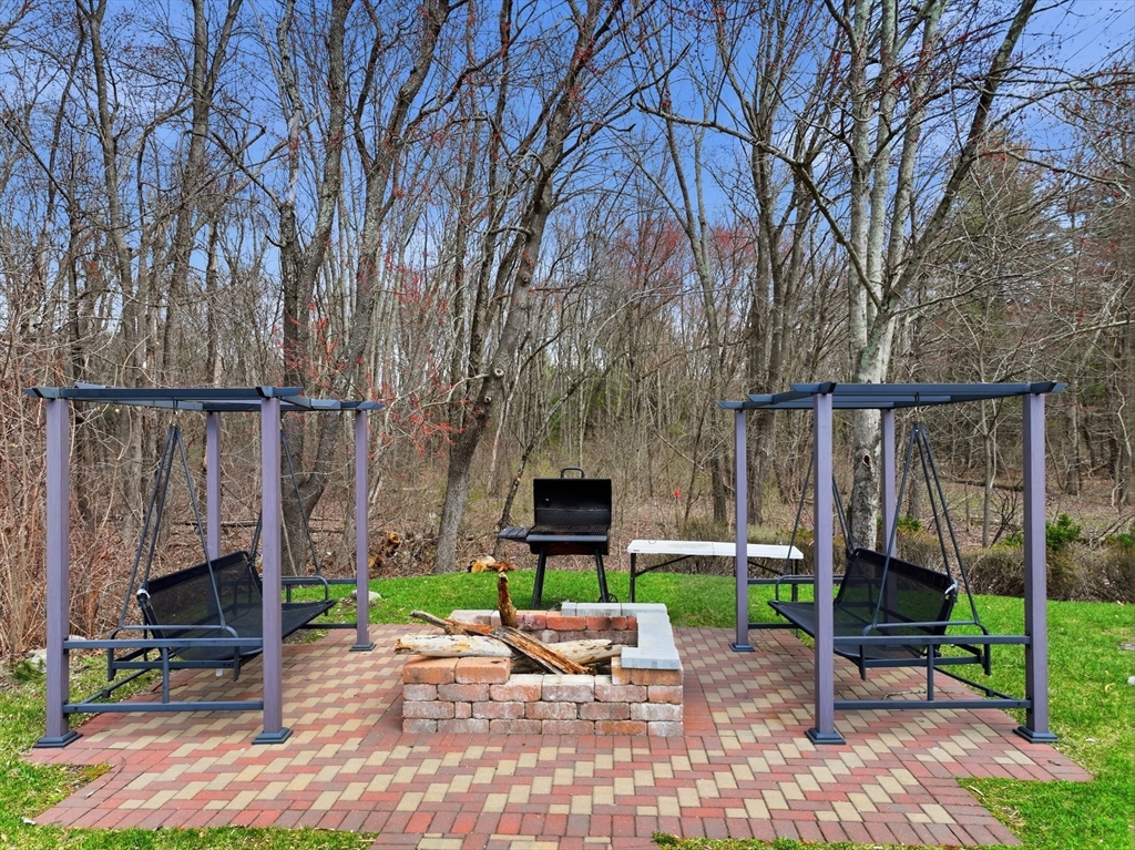 146 Hecla Street, Unit 2 Uxbridge, MA 01569 - Photo 8 of 26 a view of a chair and table in backyard of the house