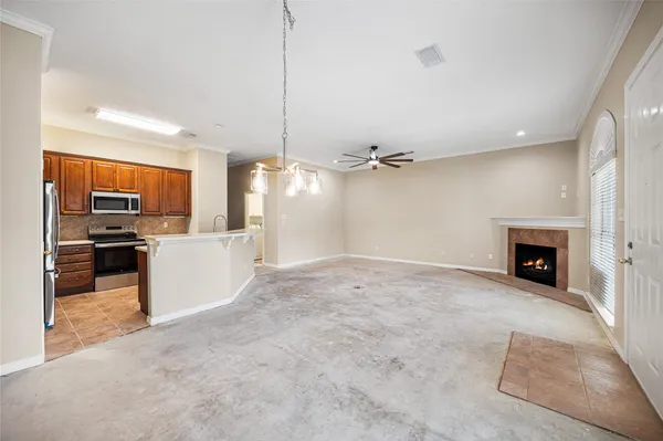 a view of a livingroom with a fireplace and a chandelier fan