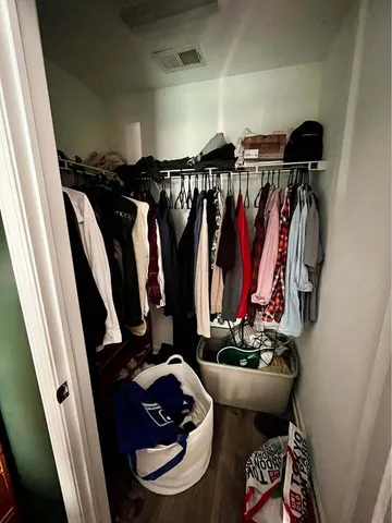 a view of walk in closet with clothes and shoes