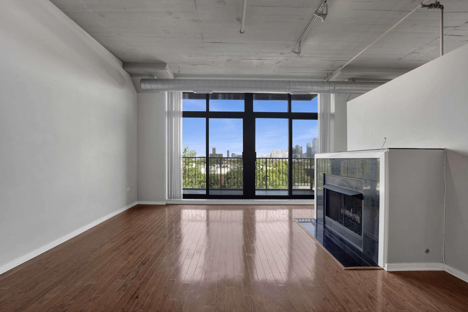 1525 South Sangamon Street, Unit 504 Chicago, IL 60608 - Photo 2 of 32 a view of an empty room with wooden floor fireplace and a window