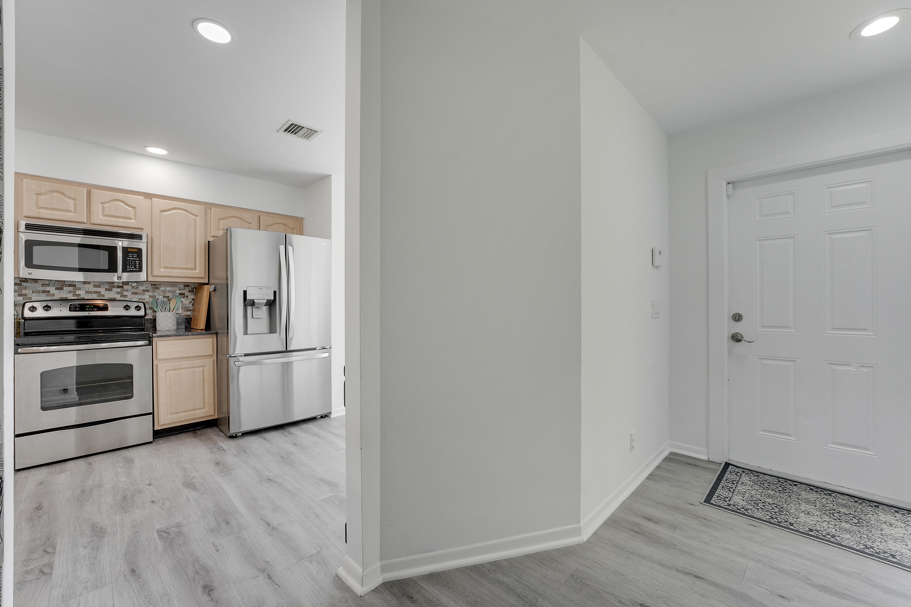 6263 Riverwalk Lane, Unit 2 Jupiter, FL 33458 - Photo 12 of 44 a kitchen with granite countertop a refrigerator and a stove top oven