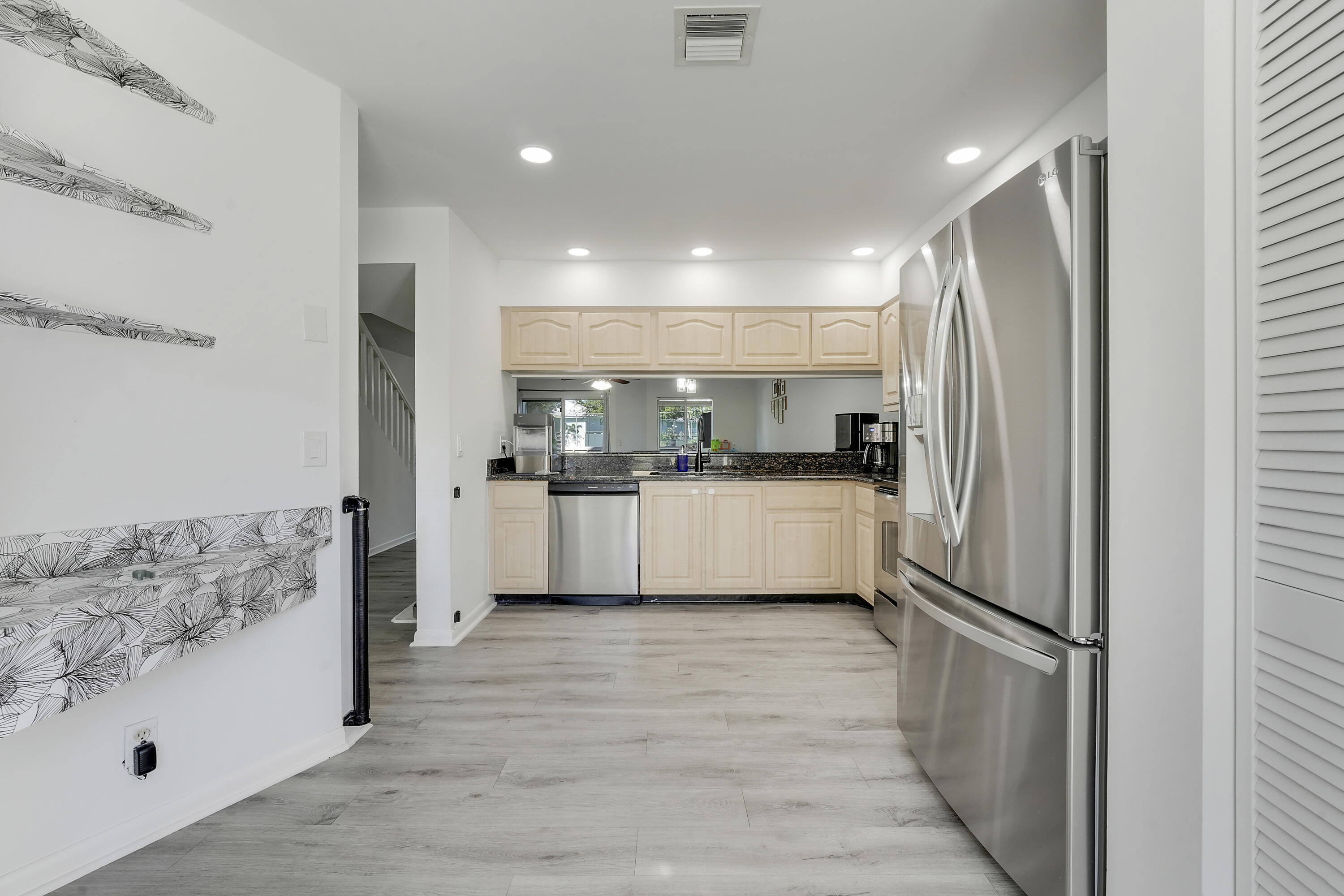 6263 Riverwalk Lane, Unit 2 Jupiter, FL 33458 - Photo 14 of 44 a kitchen with stainless steel appliances a refrigerator sink and cabinets