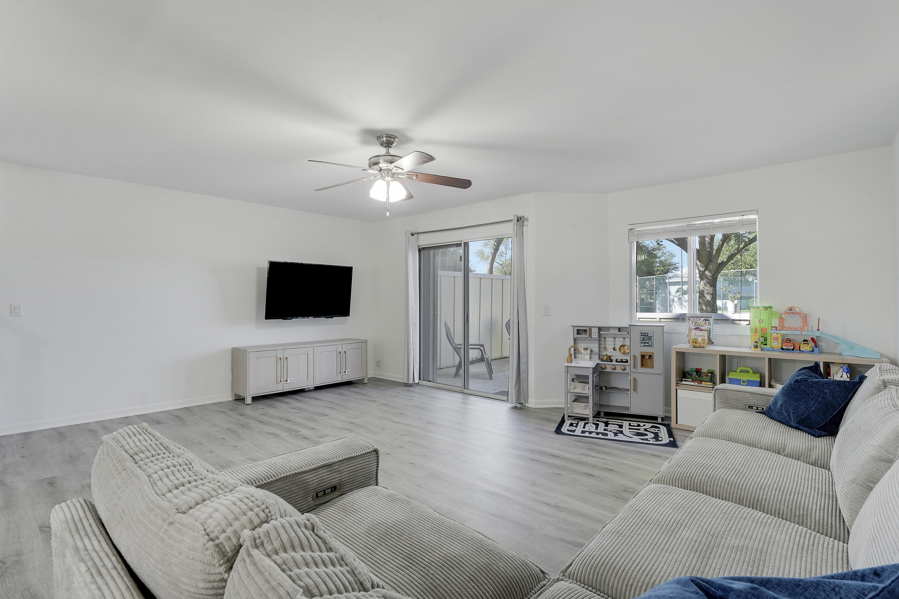 6263 Riverwalk Lane, Unit 2 Jupiter, FL 33458 - Photo 22 of 44 a living room with furniture and a flat screen tv