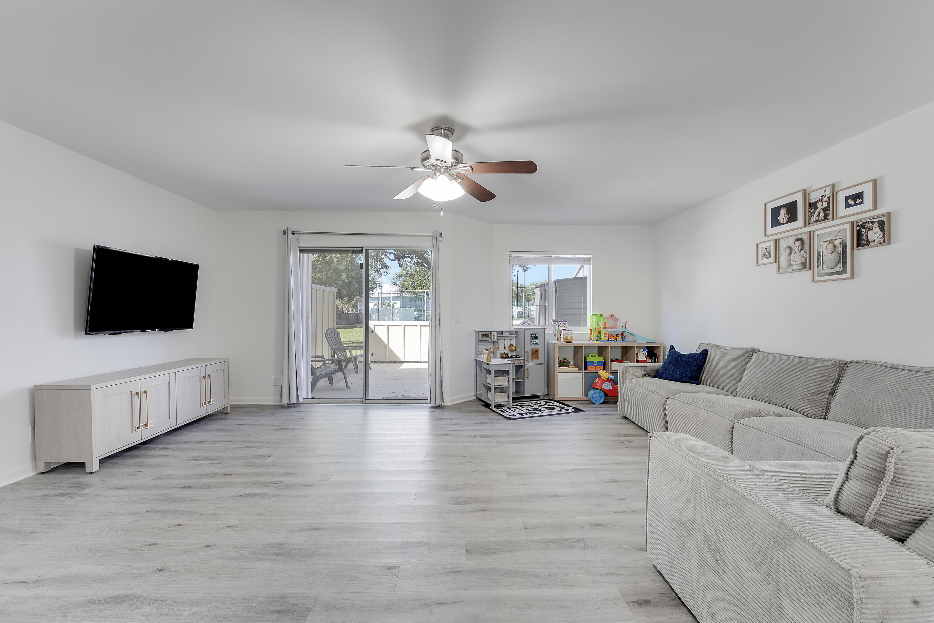 6263 Riverwalk Lane, Unit 2 Jupiter, FL 33458 - Photo 34 of 44 a living room with furniture and a flat screen tv