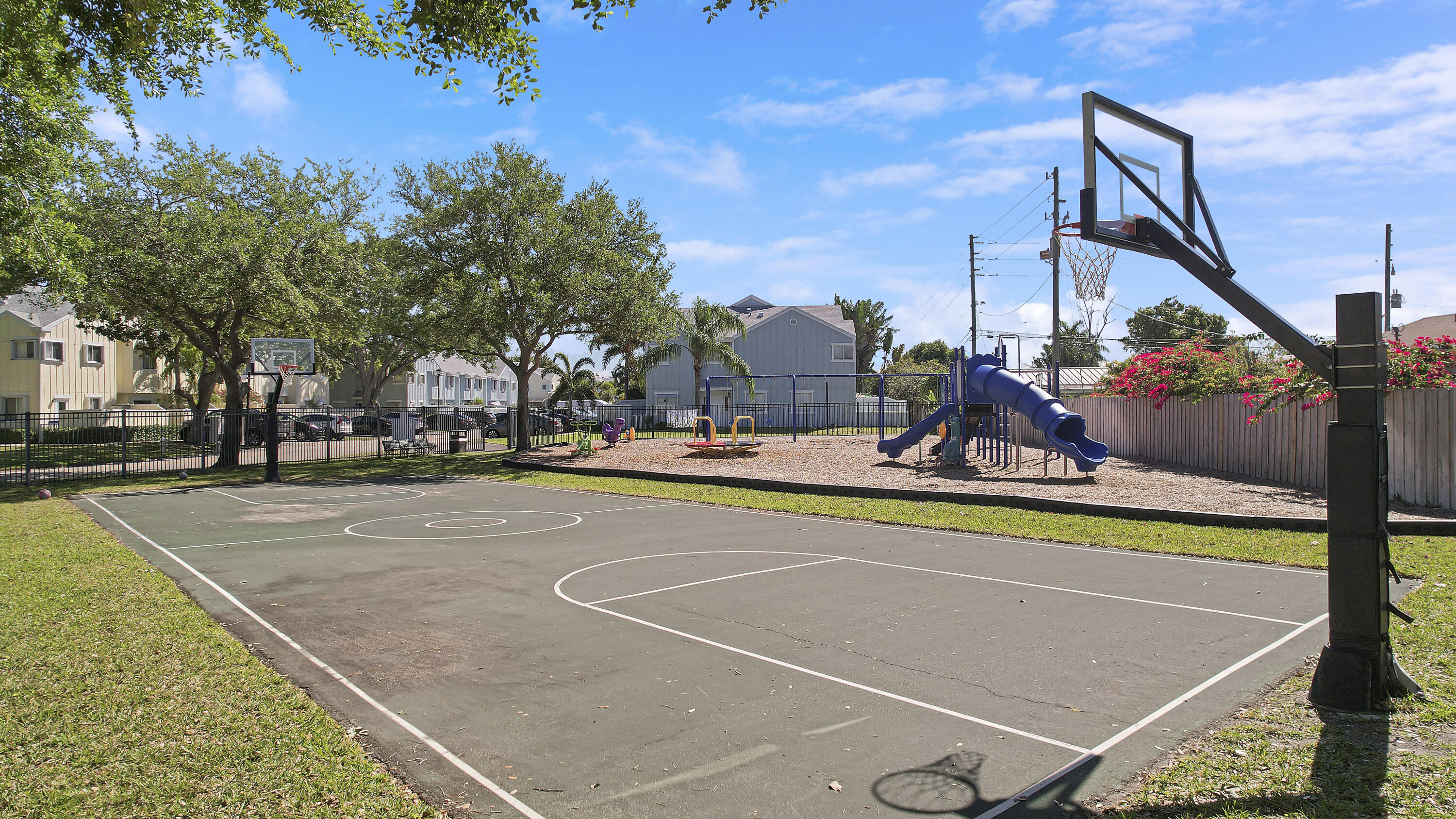 6263 Riverwalk Lane, Unit 2 Jupiter, FL 33458 - Photo 40 of 44 a view of a swimming pool with a bench and trees in the background