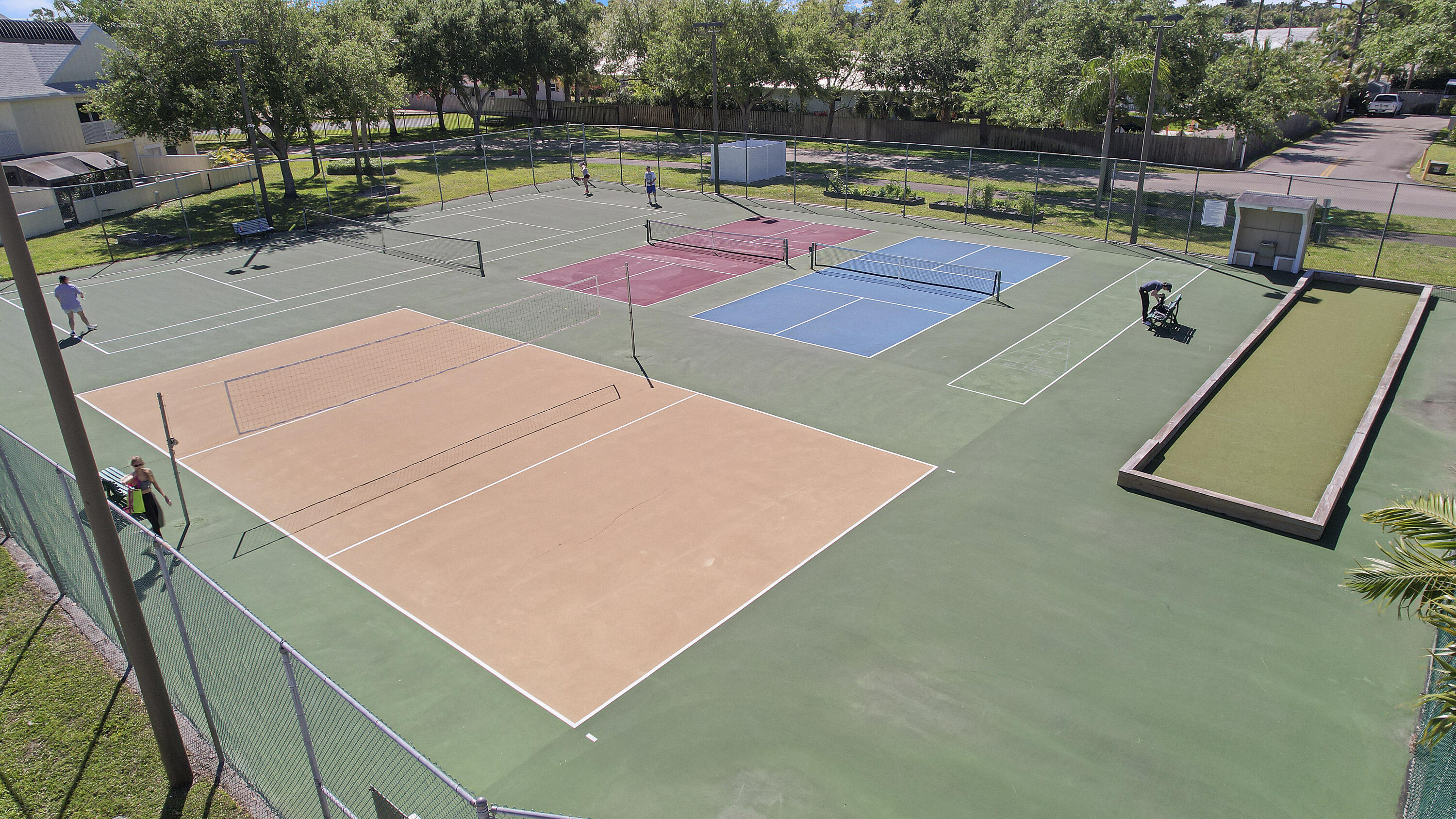 6263 Riverwalk Lane, Unit 2 Jupiter, FL 33458 - Photo 43 of 44 a view of a tennis ground with large trees