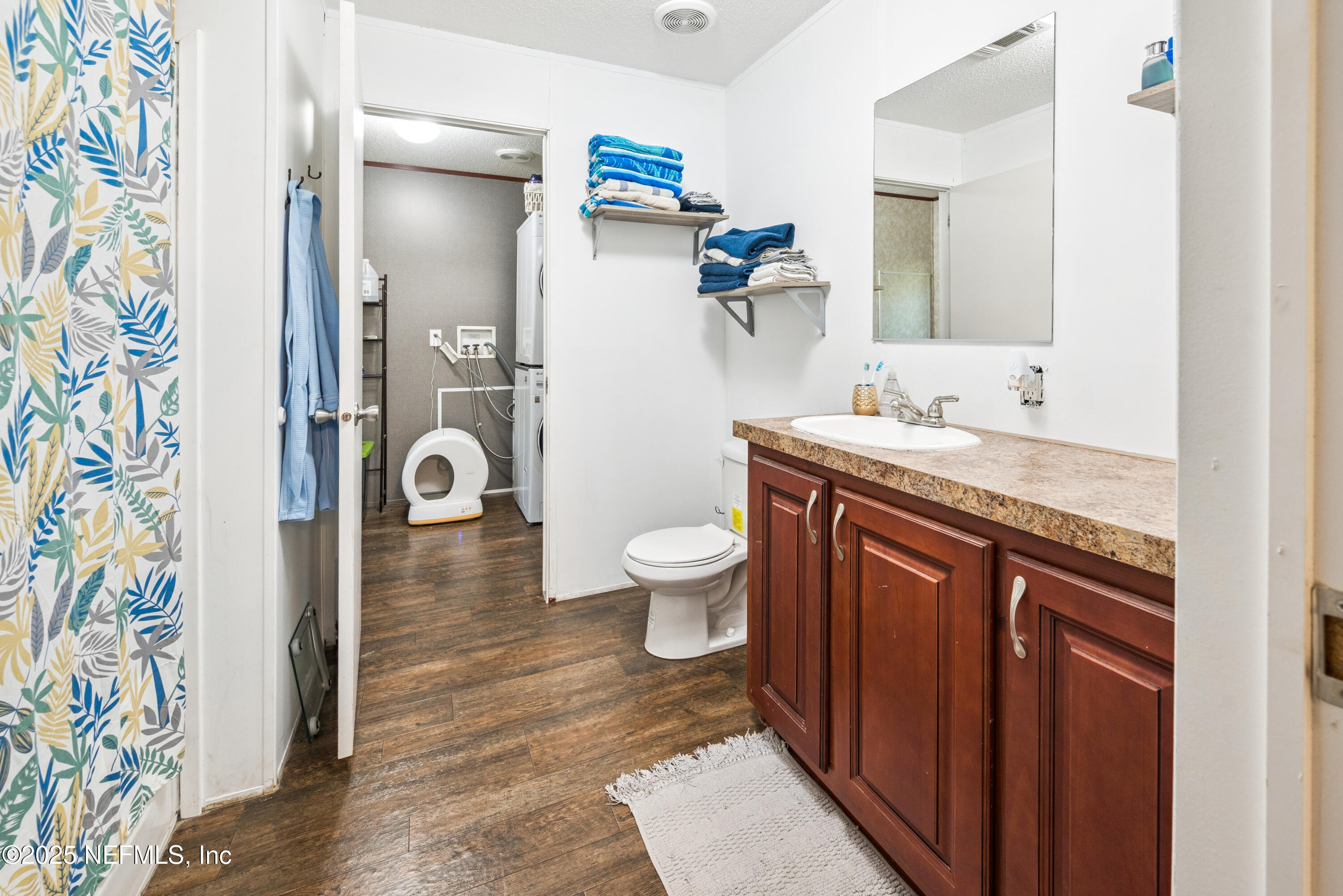 7236 Southeast 163rd Lane Lake Butler, FL 32054 - Photo 22 of 35 a spacious bathroom with a granite countertop sink a toilet a mirror and shower curtain