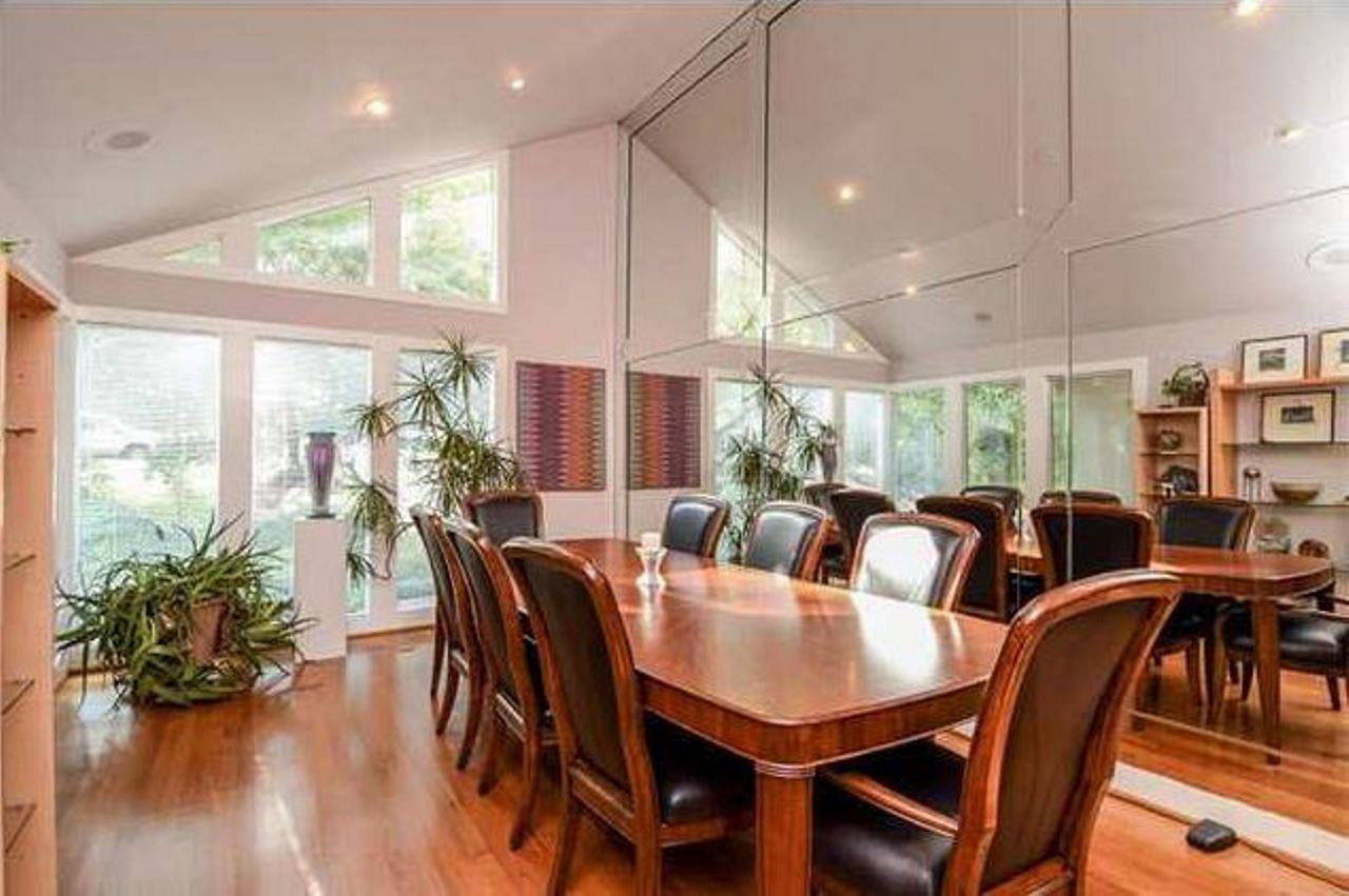 6909 Slade Hill Road Raleigh, NC 27615 - Photo 4 of 25 Large dining room with recessed lights, hardwood floors, vaulted ceiling, lots of light (morning sun). Beautiful mirrored space. Dining room looks out over surprisingly private front yard garden and incredible Japanese Maple and "Purple Smoketree" Dining Room