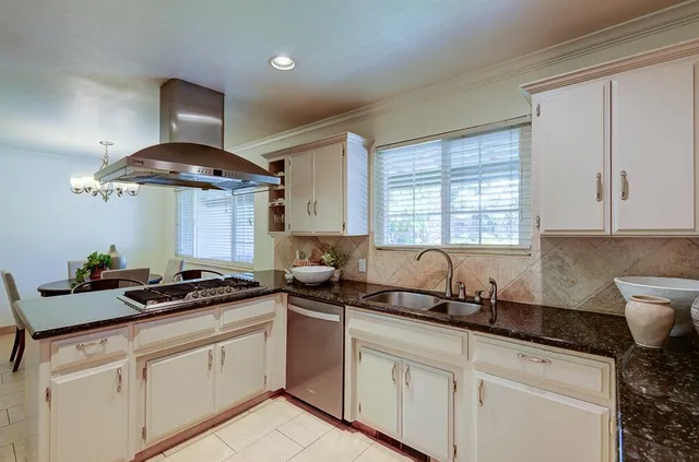a kitchen with a sink a stove and cabinets