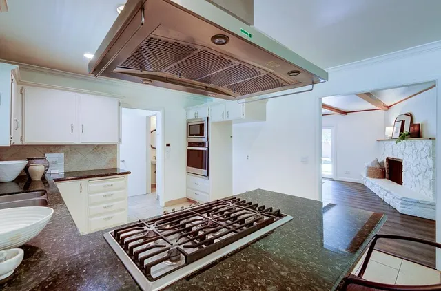a kitchen with stove and cabinets