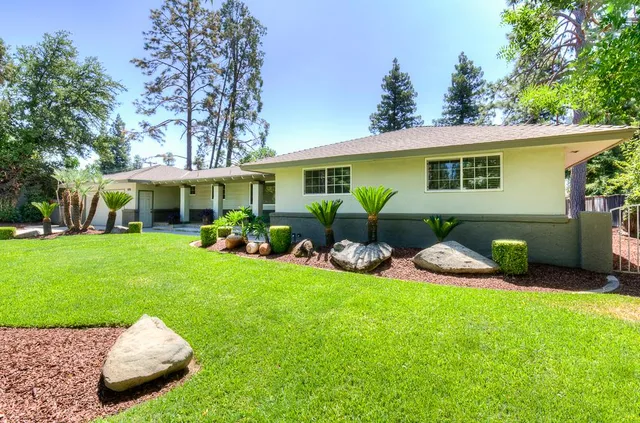 a view of a house with a backyard and a patio