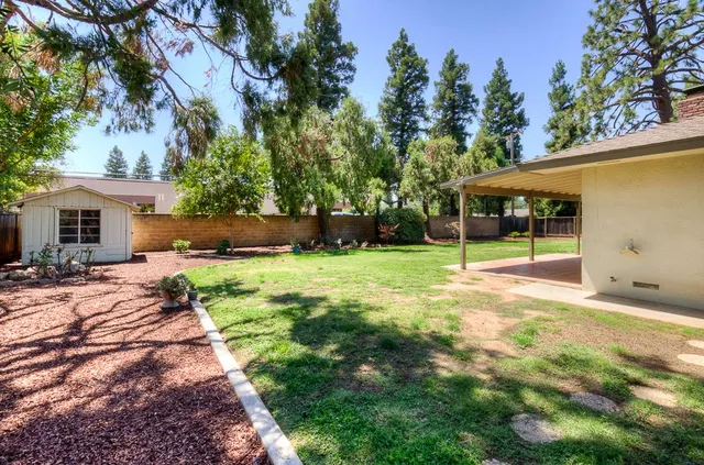 a view of a house with backyard and sitting area