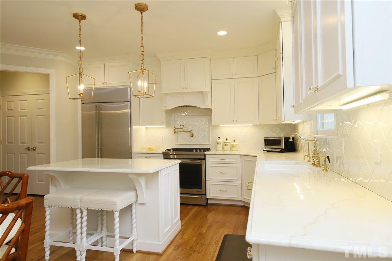 3112 Agecroft Road Raleigh, NC 27608 - Photo 8 of 29 a kitchen with stainless steel appliances granite countertop a stove a sink a refrigerator a oven a kitchen island with white cabinets and wooden floor