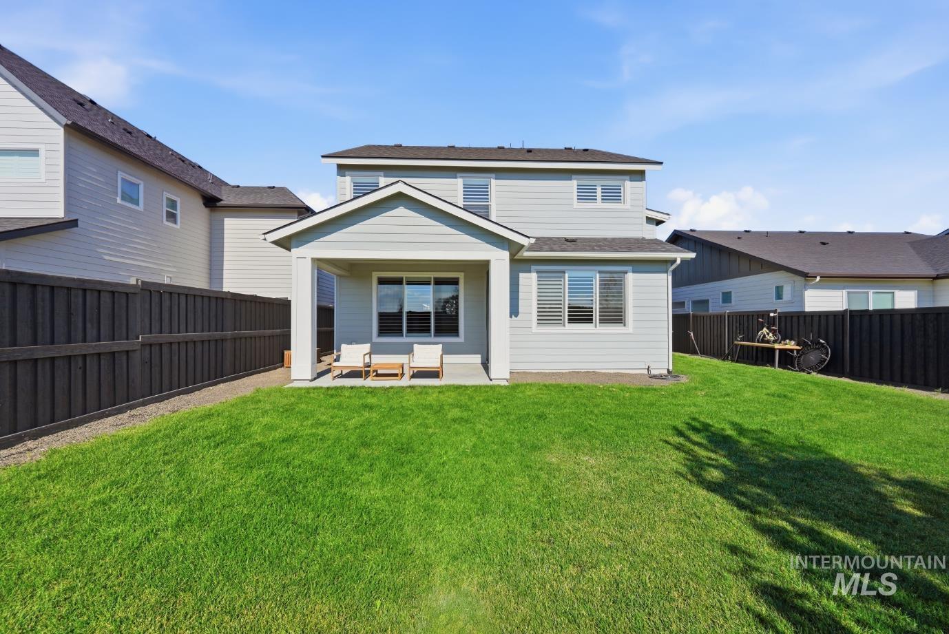 6933 South Zenith Avenue Meridian, ID 83642 - Photo 32 of 34 Expansive backyard featuring a large green lawn, covered patio, and privacy fencing