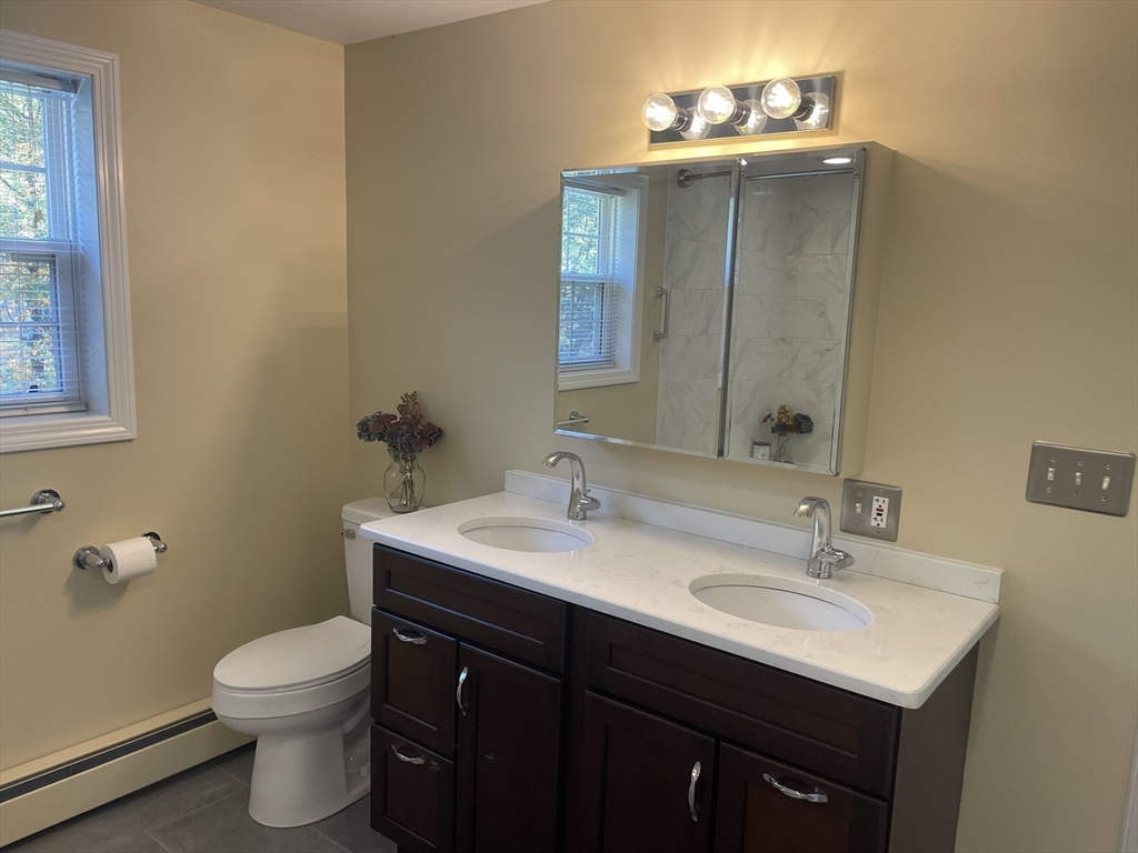 75 Downey Road North Brookfield, MA 01535 - Photo 26 of 42 a bathroom with a toilet a sink a vanity and mirror