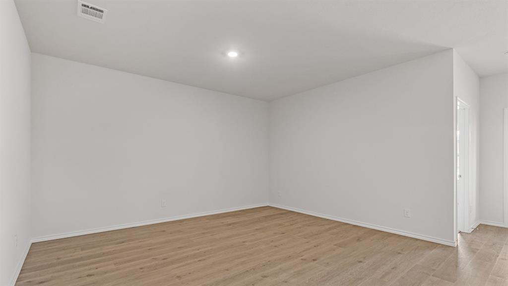 1923 Reveille Way Terrell, TX 75160 - Photo 13 of 33 Open room featuring wood-finish flooring, white walls, recessed lighting, and a ceiling vent