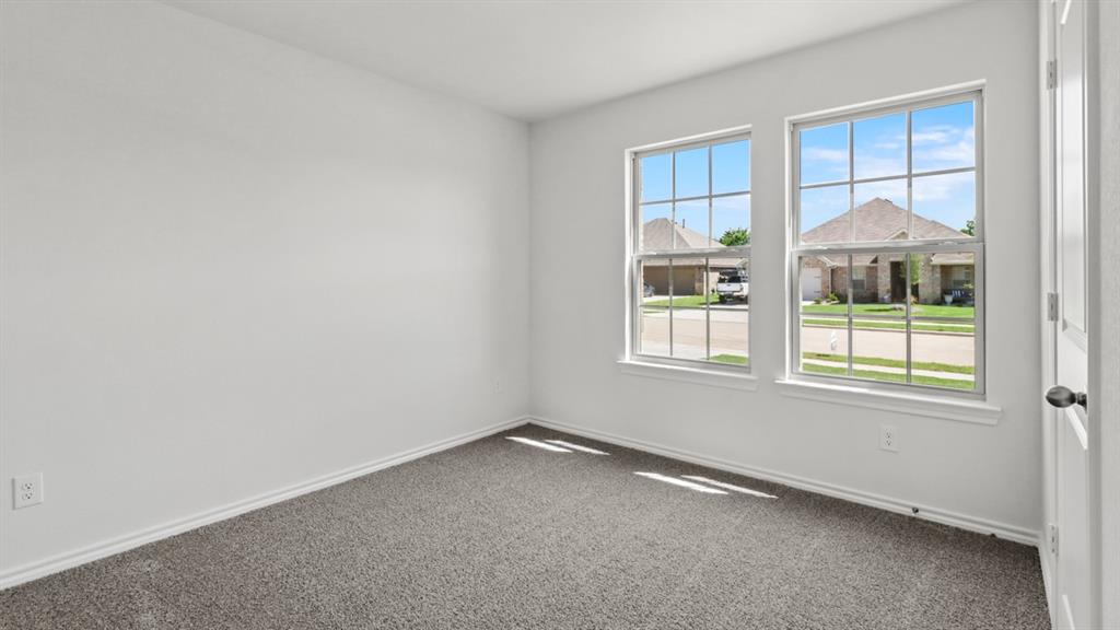 1923 Reveille Way Terrell, TX 75160 - Photo 24 of 33 Room featuring two large windows with grid inserts, light gray carpet, white baseboards, and white walls