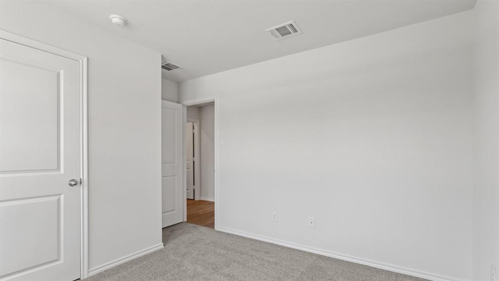 1923 Reveille Way Terrell, TX 75160 - Photo 26 of 33 Room featuring neutral wall paint, gray carpet flooring, white baseboards, and a white paneled door