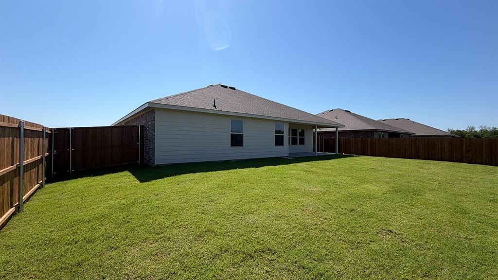 1923 Reveille Way Terrell, TX 75160 - Photo 29 of 33 Spacious backyard featuring a manicured lawn, full perimeter wood fencing, and a covered patio area