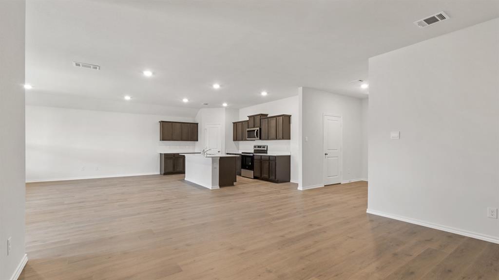 1923 Reveille Way Terrell, TX 75160 - Photo 4 of 33 Open-concept living space featuring wood-finish flooring, recessed lighting, and a white color palette