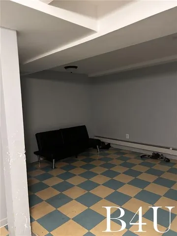 a living room with a black white checkered floor with a gaming machine and dining table