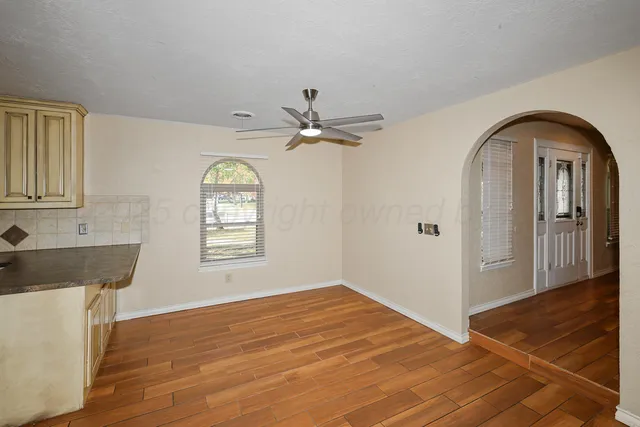 a kitchen with granite countertop a sink cabinets stainless steel appliances and a window