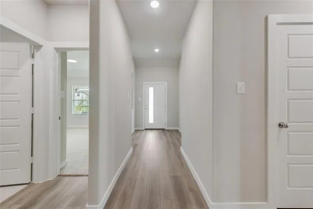 a view of a hallway with wooden floor