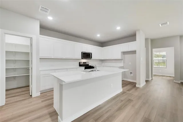 a view of kitchen with sink microwave and refrigerator