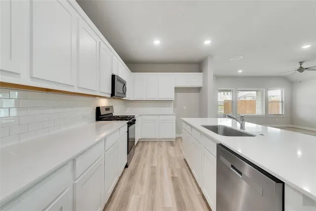 a kitchen with a sink stove and cabinets