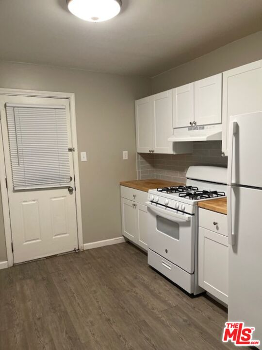 1608 E Street Bakersfield, CA 93301 - Photo 20 of 34 a kitchen with granite countertop white cabinets and white appliances