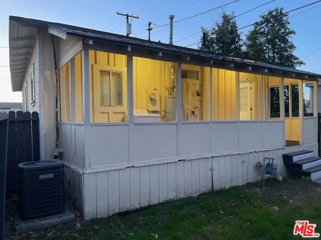a view of a house with backyard and wooden fence