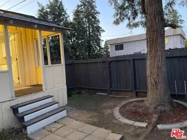 a view of a house with backyard and wooden fence