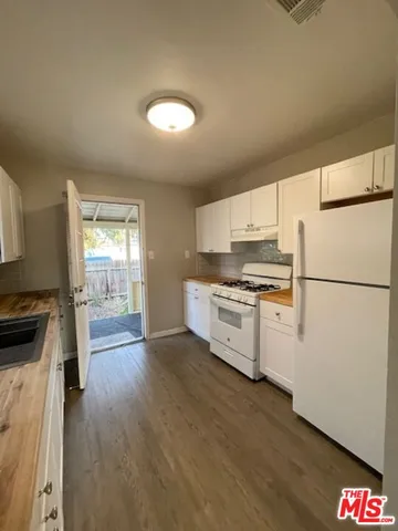 a kitchen with granite countertop a refrigerator and a stove top oven