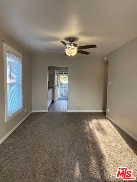 1608 E Street Bakersfield, CA 93301 - Photo 9 of 34 an empty room with chandelier fan and windows