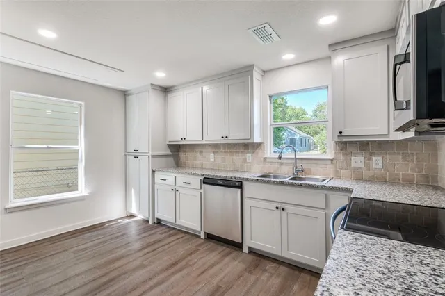 a kitchen with a sink wooden floor and a window