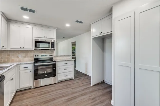 a kitchen with wooden floors and appliances