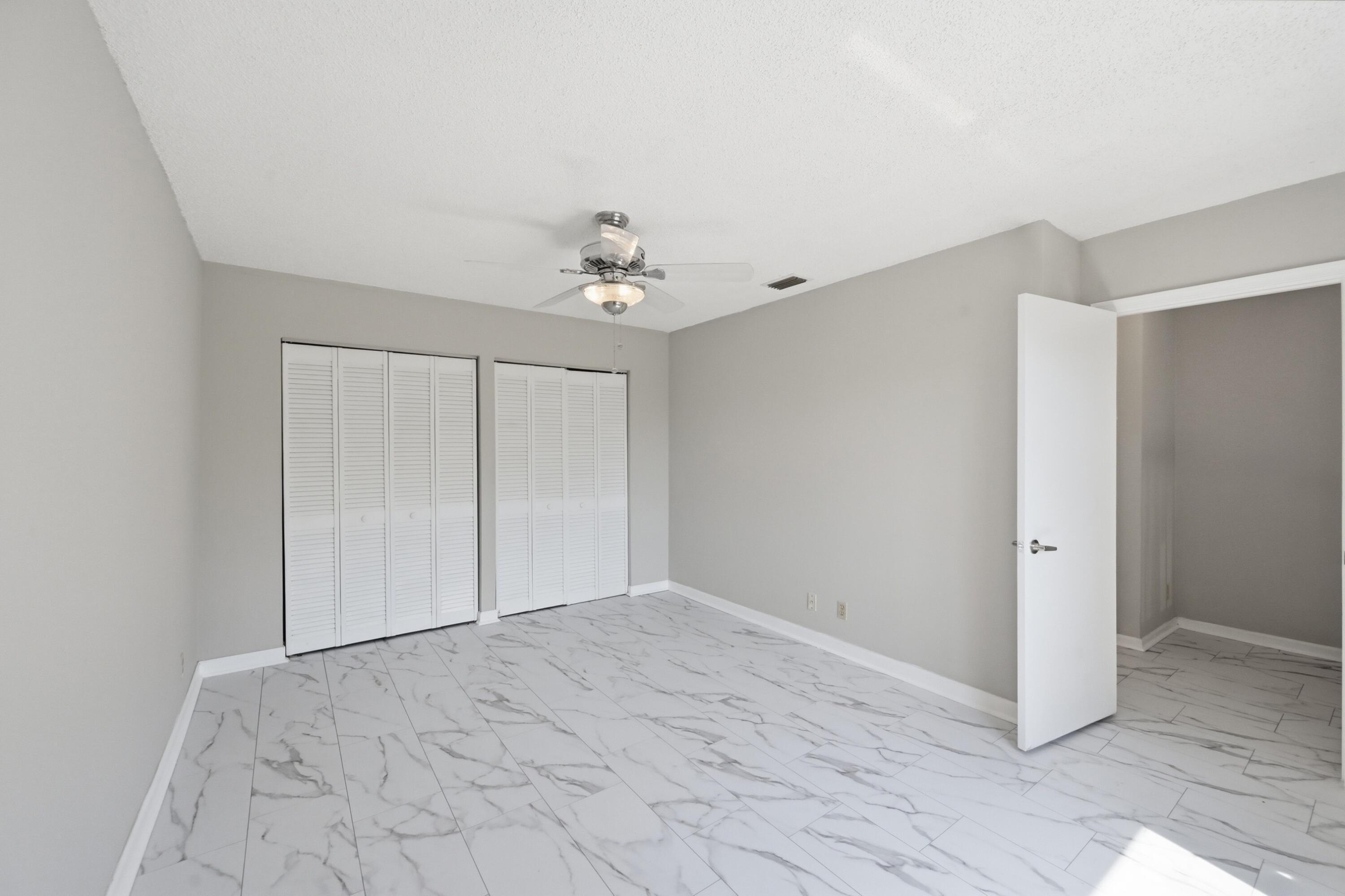9364 Ketay Circle, Unit 5 Boca Raton, FL 33428 - Photo 20 of 42 a view of an empty room with a chandelier fan