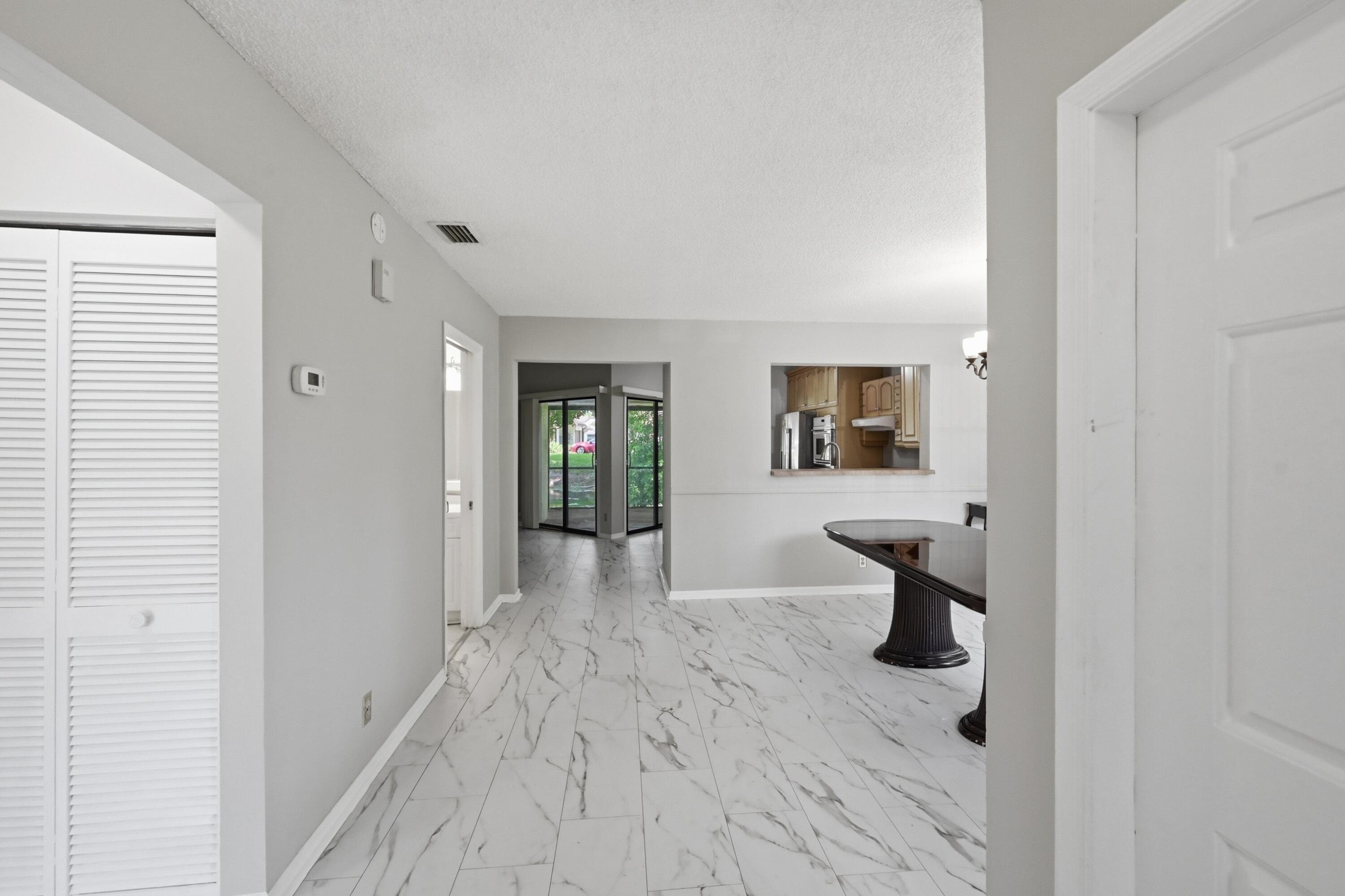 9364 Ketay Circle, Unit 5 Boca Raton, FL 33428 - Photo 4 of 42 a view of a livingroom with wooden floor and a bathroom