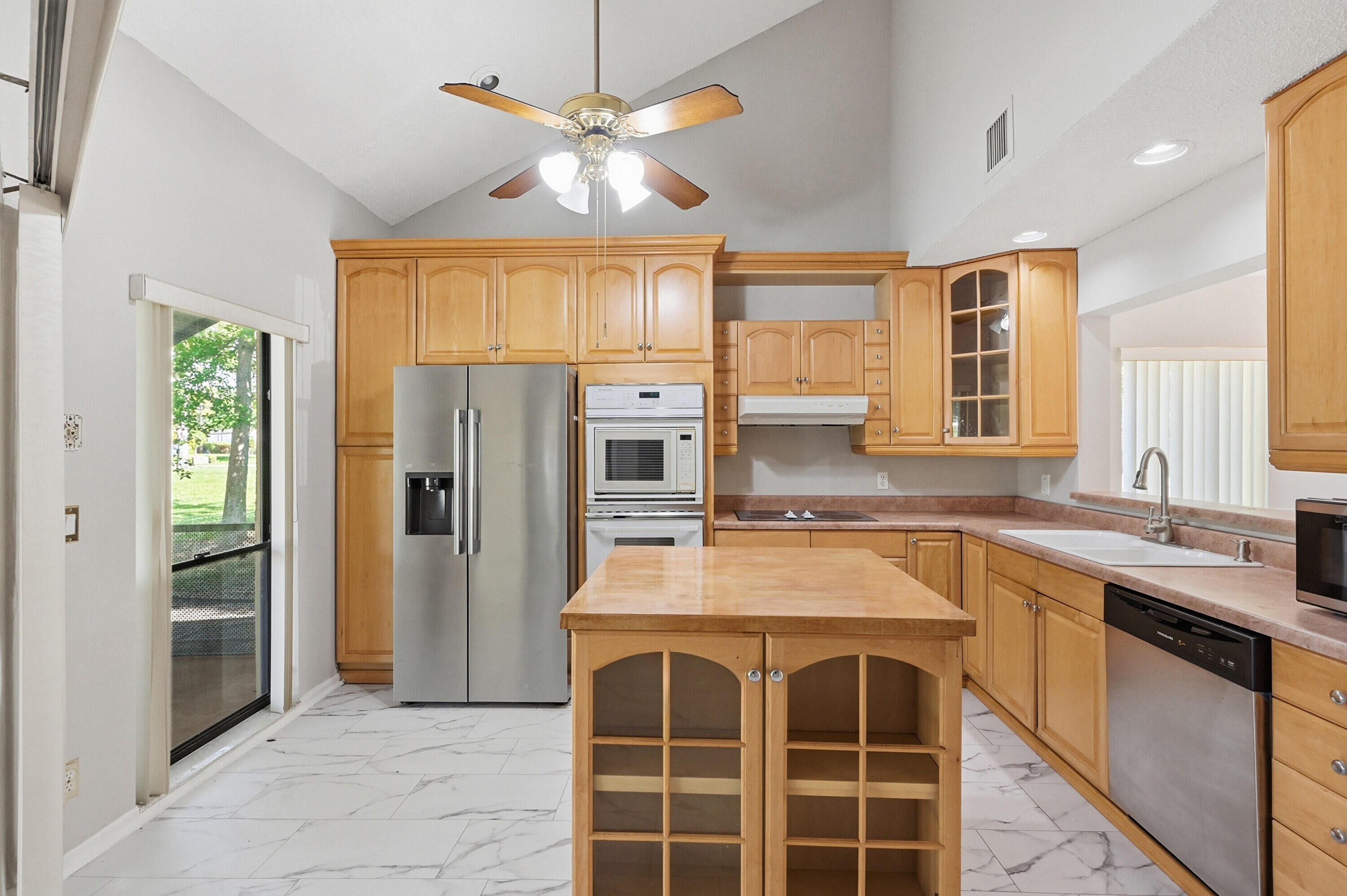 9364 Ketay Circle, Unit 5 Boca Raton, FL 33428 - Photo 7 of 42 a kitchen with stainless steel appliances a stove a refrigerator and a sink