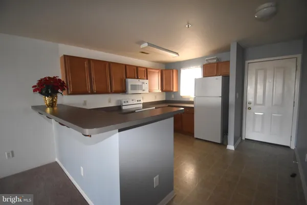 a kitchen with granite countertop a refrigerator and a sink
