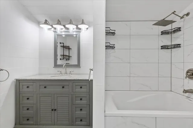 a bathroom with a bathtub sink and mirror