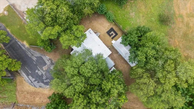 an aerial view of a house with a yard and large trees