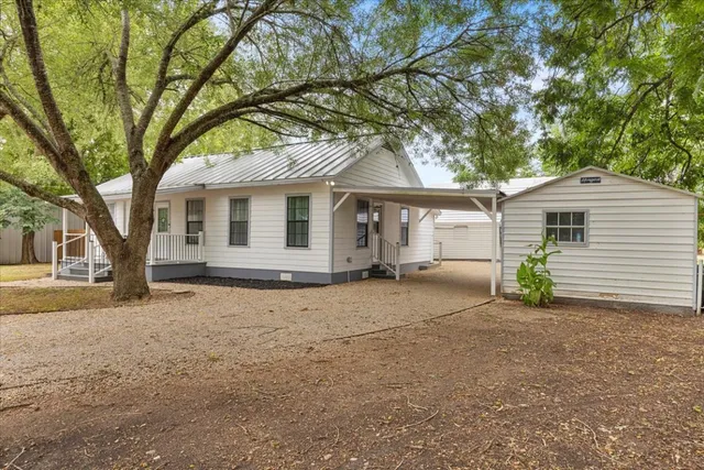 a view of a house with a large tree and a big yard