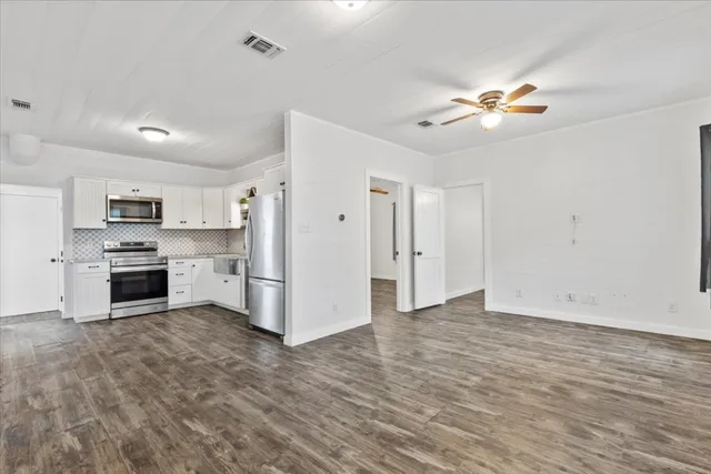 a view of kitchen with wooden floor and electronic appliances