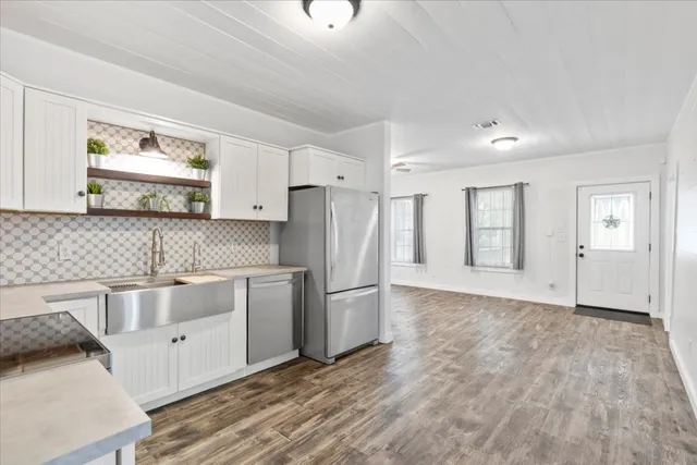 a kitchen with stainless steel appliances granite countertop a refrigerator and a stove top oven